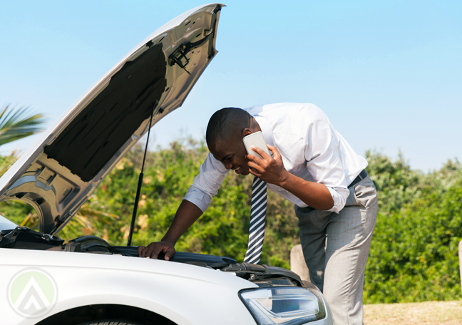 man on phone call looking at car trouble