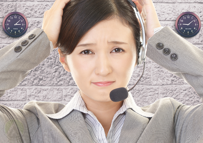 stressed asian call center agent with wall clocks in background