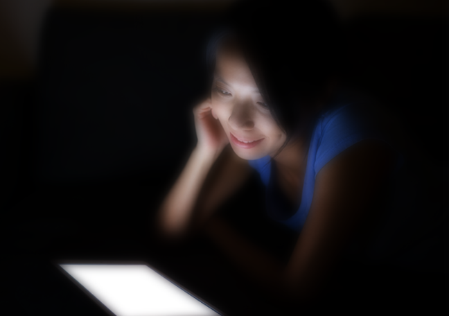 woman reading tablet in the dark