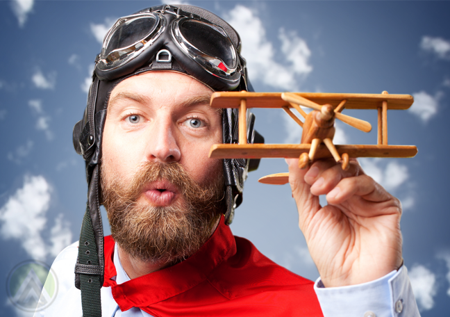 bearded man playing with toy plane blue sky backdrop