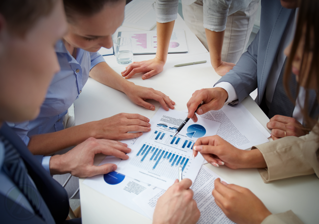 business executives looking over printed charts