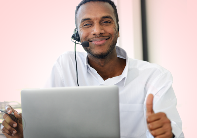 smiling call center agent by laptop thumbs up