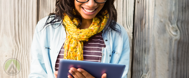 smiling-woman-in-glasses-reading-tablet-computer