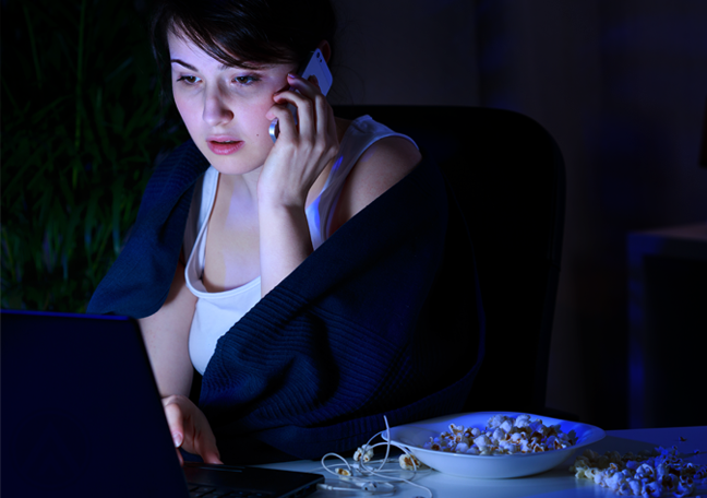 woman in phone call using laptop in dark room