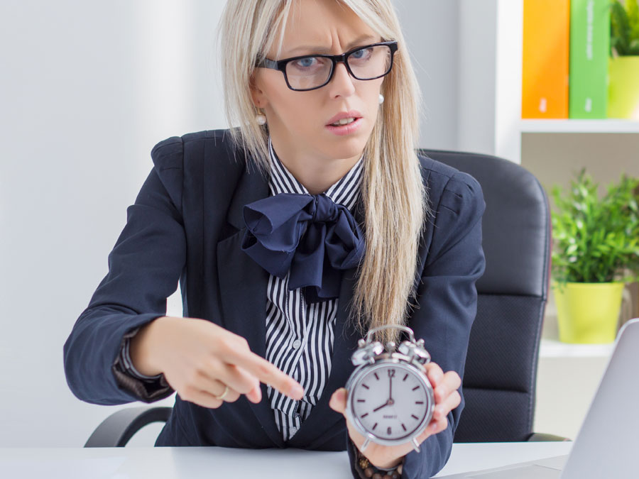 annoyed call center team leader pointing to alarm clock