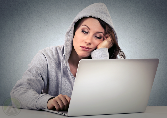 bored woman in hoodie using laptop