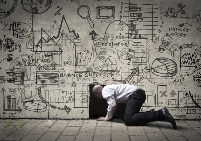 businessman kneeling opening hole in wall