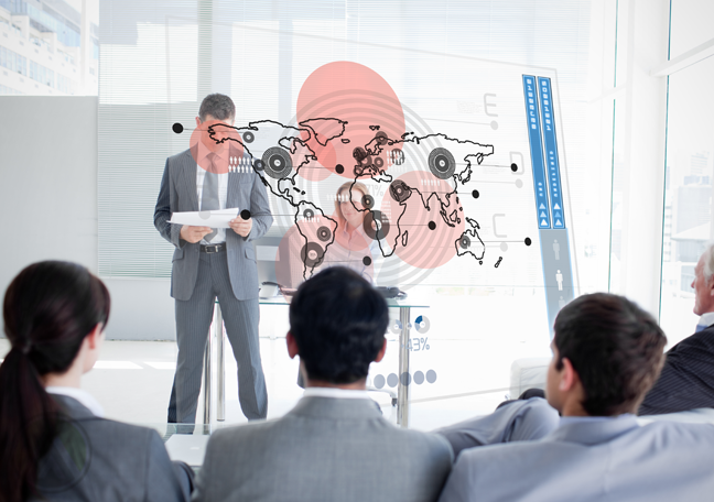 businessman looking at reports in presentation with executives watching