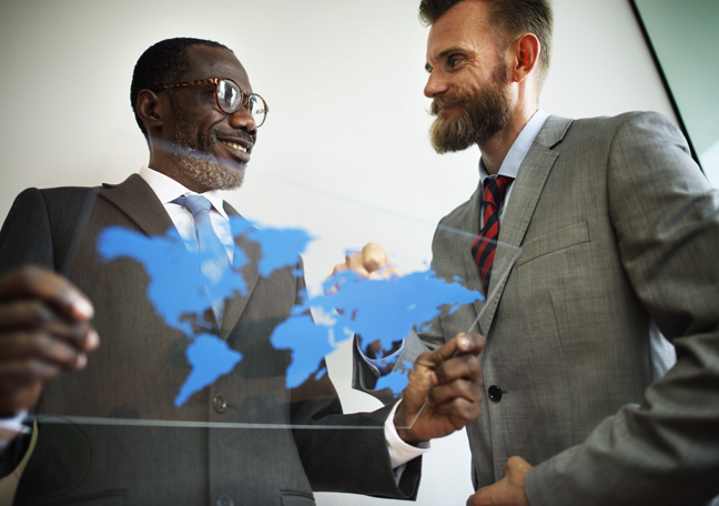 businessman looking at world map on clear glass