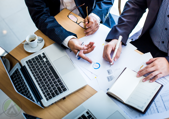 company executives in meeting studying reports 