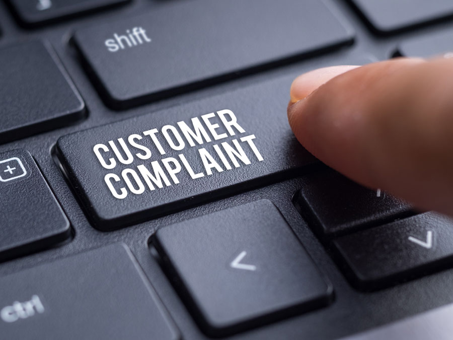 customer support depiction finger pressing laptop computer button customer complaint