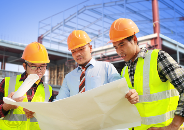 engineers at construction site looking floor plans