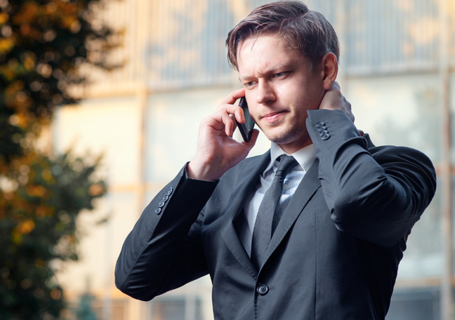 problematic businessman in phone call standing along outdoors