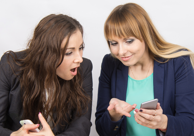 two young women talking about smartphone