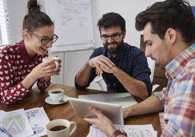 business team having fun over coffee watching tablet