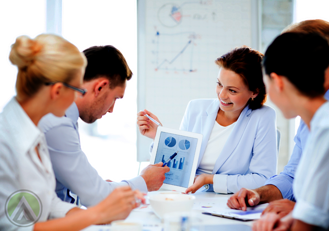 business team looking at charts graphs on tablet