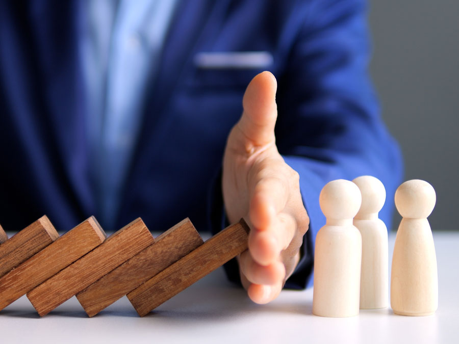 call center nightmares depiction businessman covering people figures from toppling wood blocks