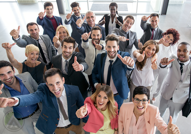 culturally diversr business team in office hallway giving thumbs up