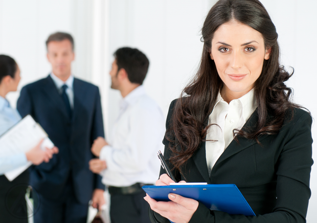 human resource manager writing on clipboard with job applicants behind her