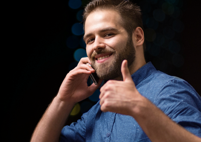 smiling man on phone giving thumbs up