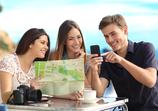 tourist group sitting outdoors looking at map smartphone