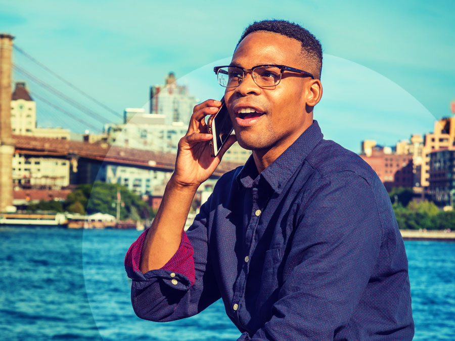 young african american man in glasses speaking on phone in seaside