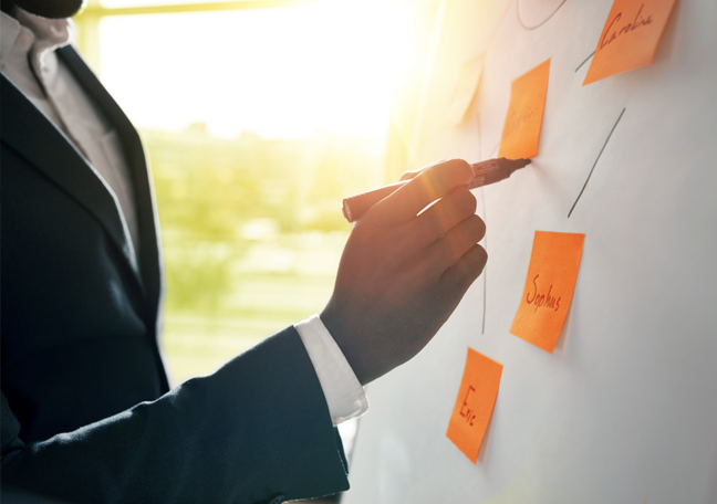 business man writing on white board with posti it notes