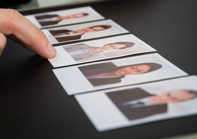 hand pointing to one photo group of executive pictures