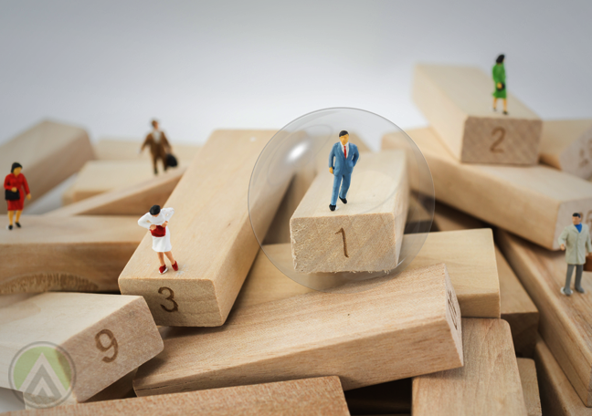 miniature business workers standing on jenga puzzle pieces