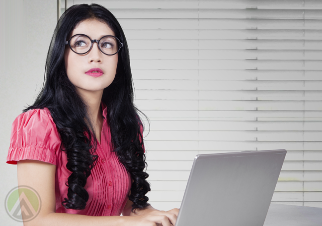 office employee thinking looking away using laptop in office