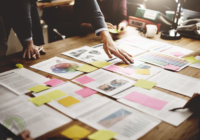 businessman hand reaching out to laid out printed reports documents charts graphs