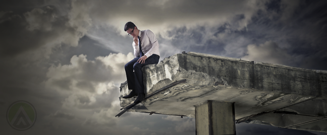 businessman sitting alone by ledge broken bridge