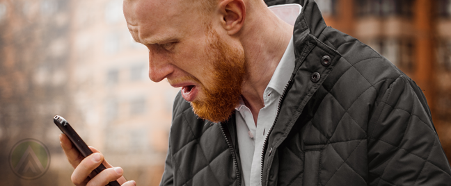 disappointed man looking at smartphone