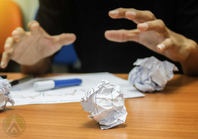 employee hands grab crumpled paper