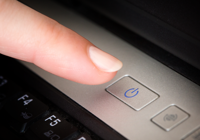 finger pushing laptop power button