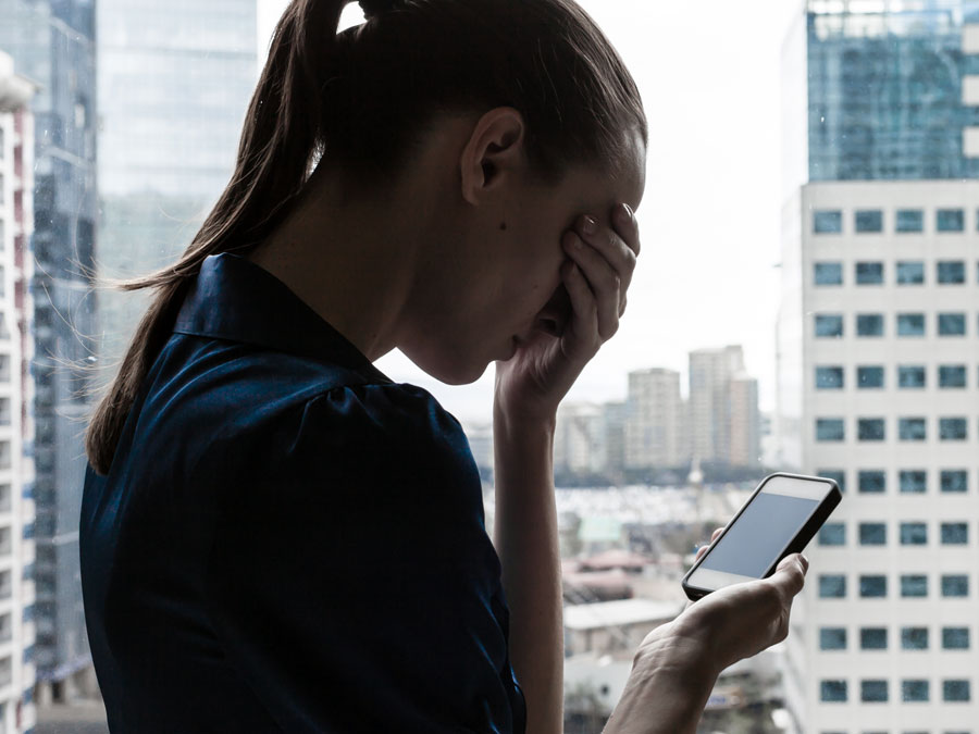 frustrated executive by window looking at phone