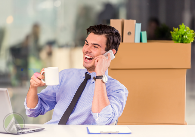 laughing office employee using smartphone phone call boxes in back