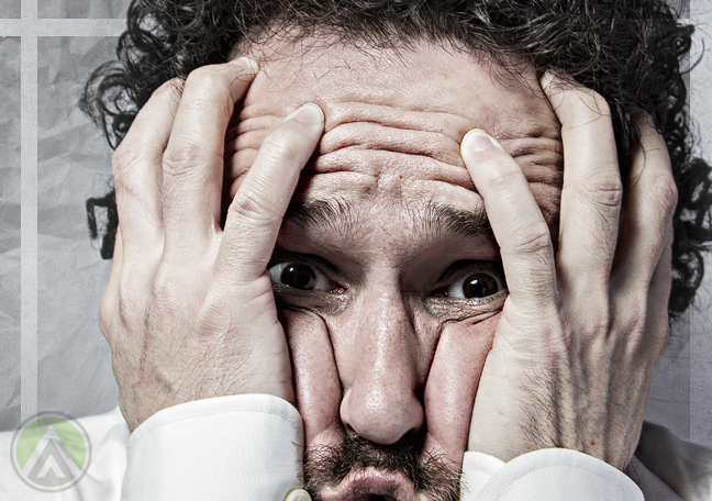 man squishing face in panic