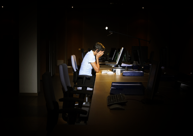 tired employee working in dark office