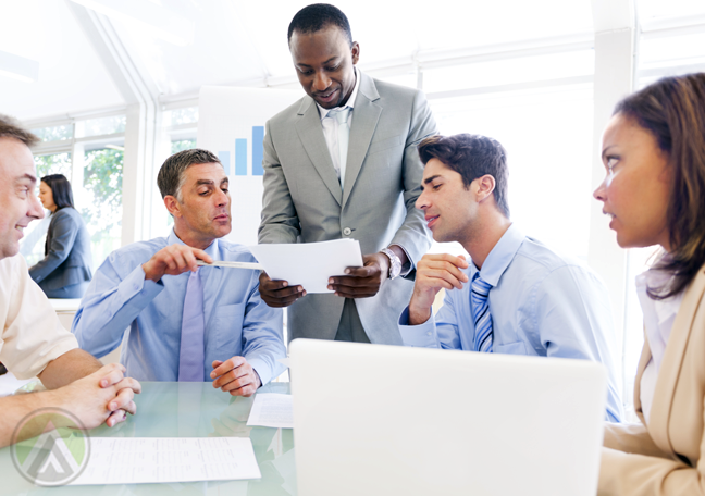 business team in meeting looking printed document