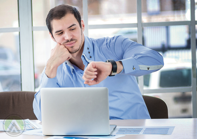 businessman using laptop impatiently looking at watch