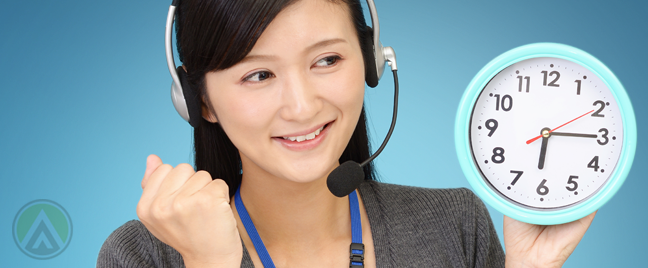 excited asian call center worker holding wall clock