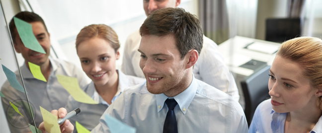 business team in meeting writing notes on post it