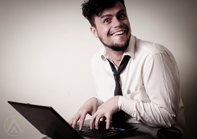 businessman using laptop with nasty grin 