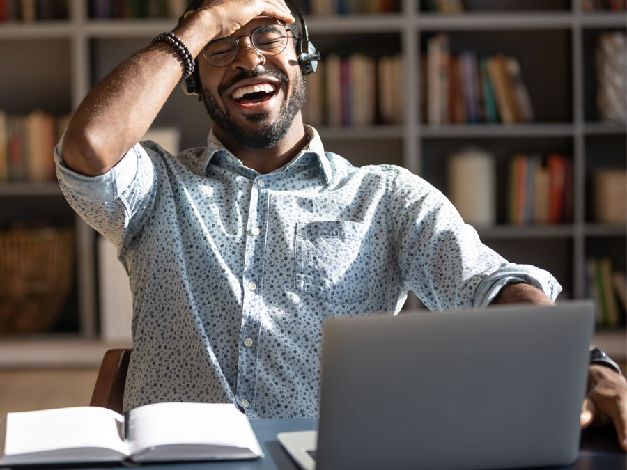 excited call center laughing in front of laptop