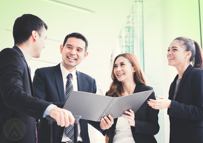 laughing Asian business team reading printed report 