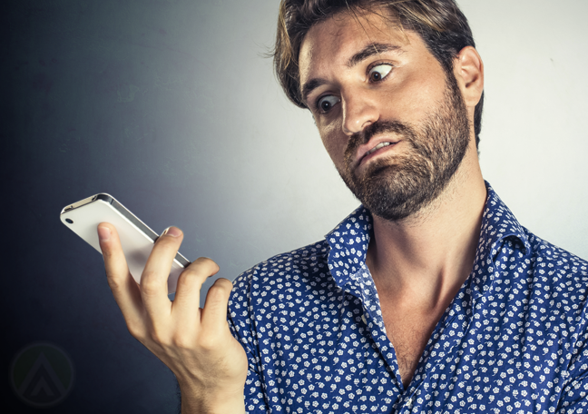 man in hawaiian blue shirt annoyed at phone