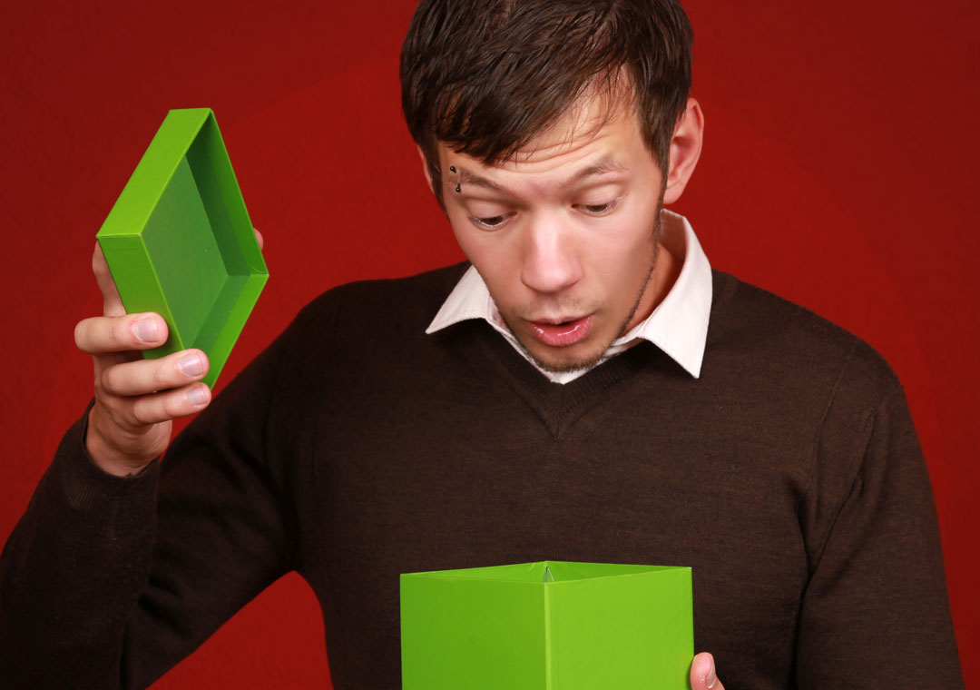 surprised young man looking into opened box gift