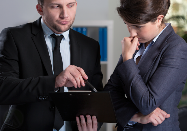 unimpressed executive pursed lips showing clipboard to worried coworker