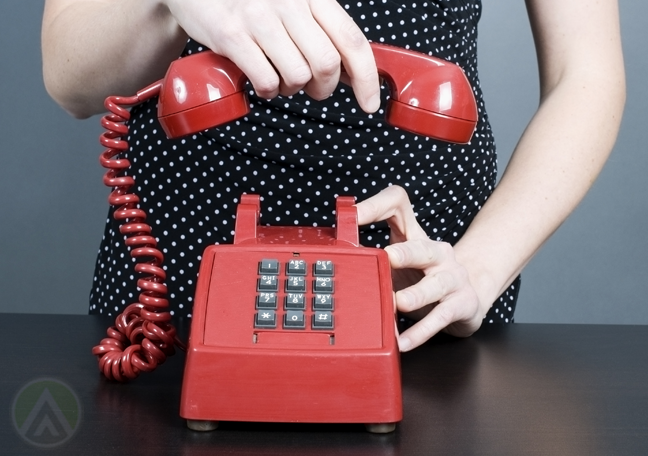 woman hanging up landline phone